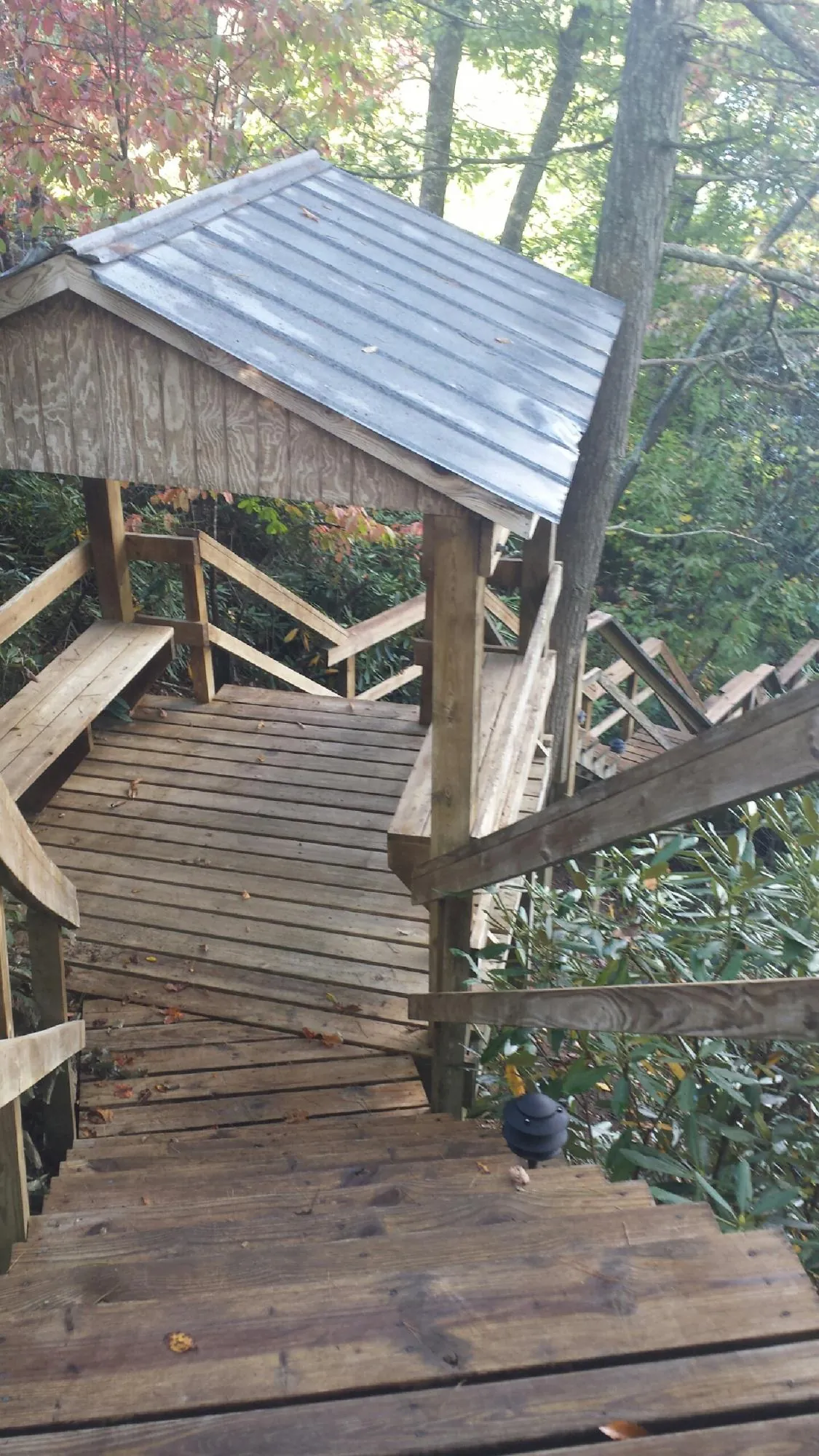 Metal roofed shelter over wooden steps on a wooded walkway — Skylight Repair & Installation work by our crew in Pennington